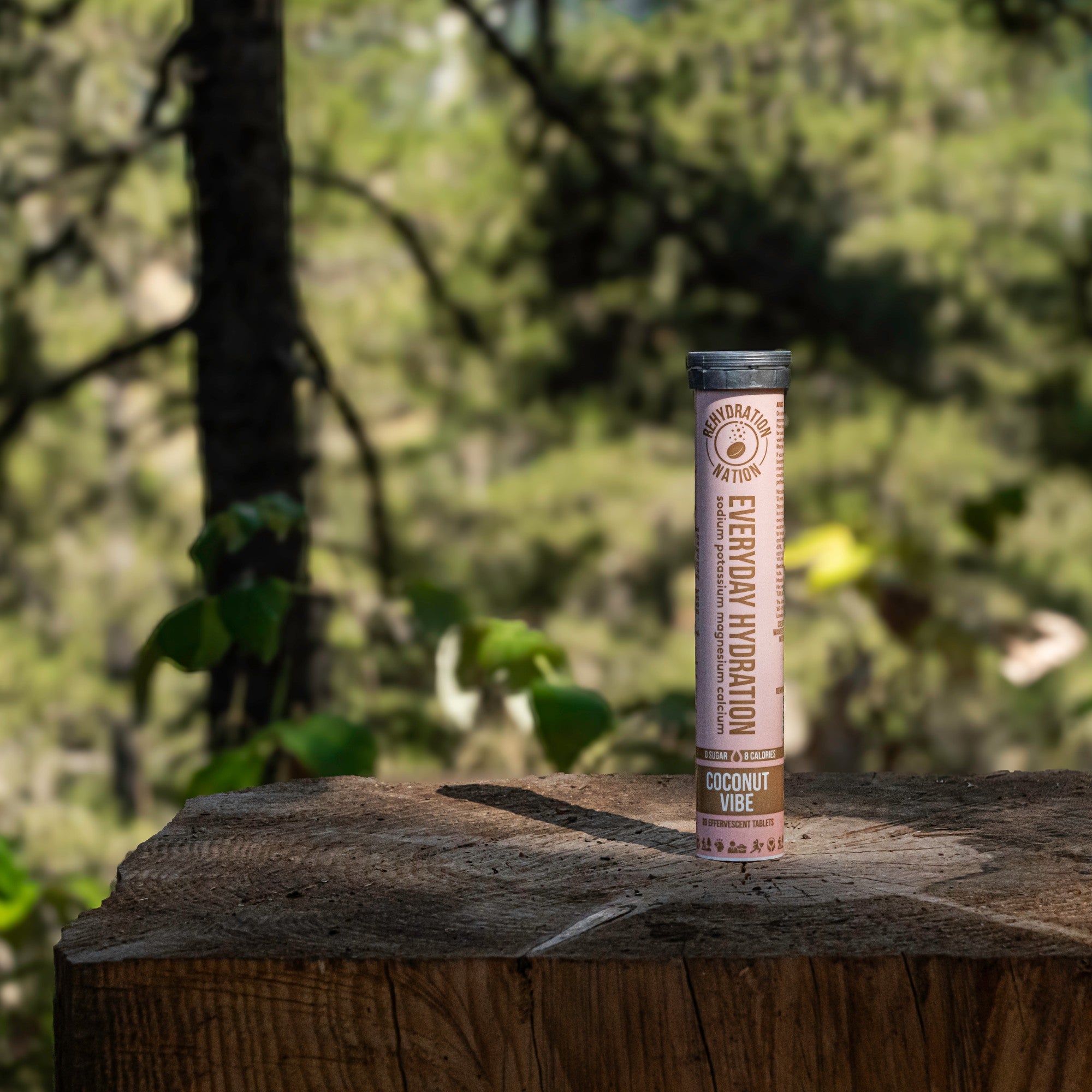 Rehydration Nation Coconut Vibe hydration tablets – tube placed on a wooden surface in a forest setting